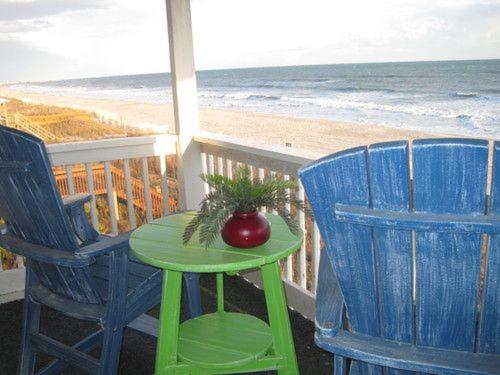 uma mesa e duas cadeiras numa varanda com praia em Next 2 Paradise-203 em Holden Beach