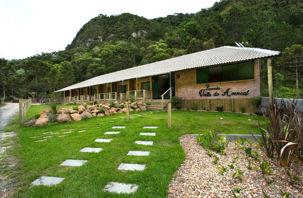 um edifício com um jardim de relva em frente em Pousada Valle do Avencal 5 Km do Centro em Urubici