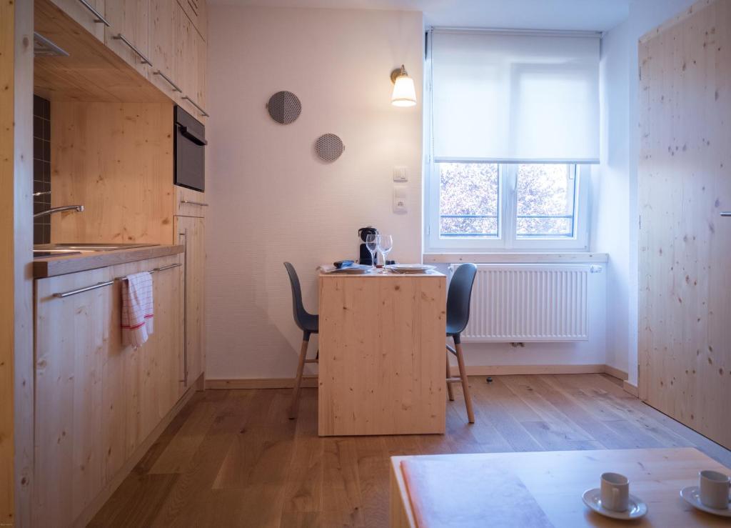 a kitchen with a table and two chairs and a window at La ferme des Colieuvres in Lièpvre