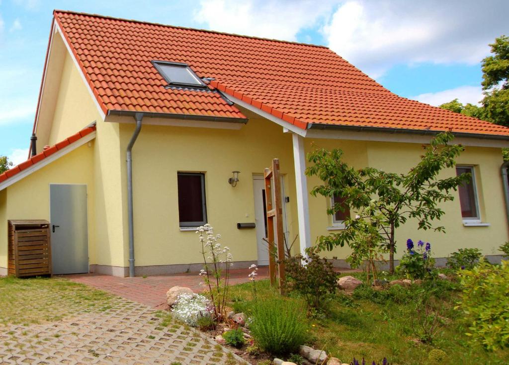 una casa amarilla con techo naranja en Ferienhaus CASA UNO, en Göhren-Lebbin