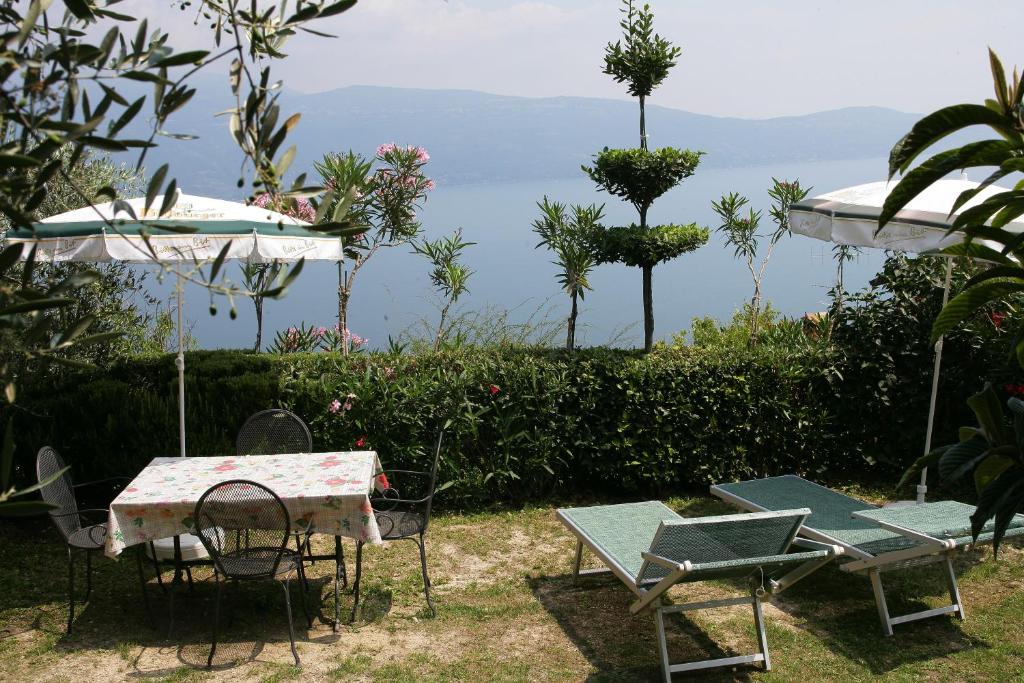 een tafel en stoelen met uitzicht op de oceaan bij Appartamenti Serena - Nonna Agnese in Gargnano