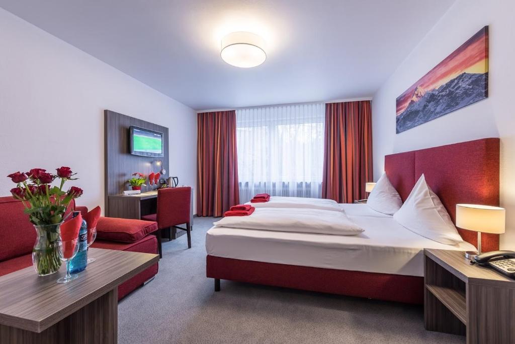 a hotel room with a bed and a living room at Hotel Himalaya Frankfurt City Messe in Frankfurt