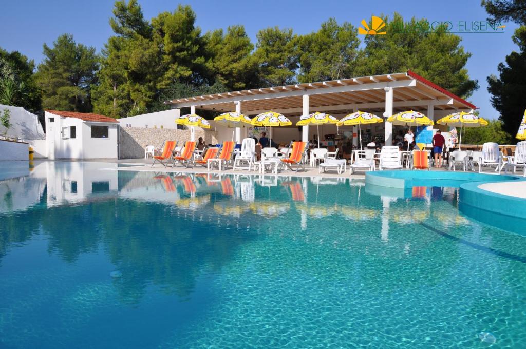 - une grande piscine avec des chaises et des parasols dans l'établissement Villaggio Elisena, à Vieste