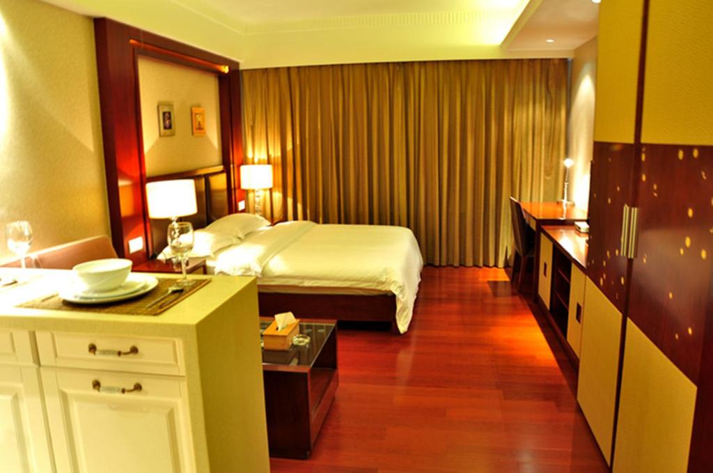 a large hotel room with a bed and a table at Ziyuan Service Apartment in Shanghai