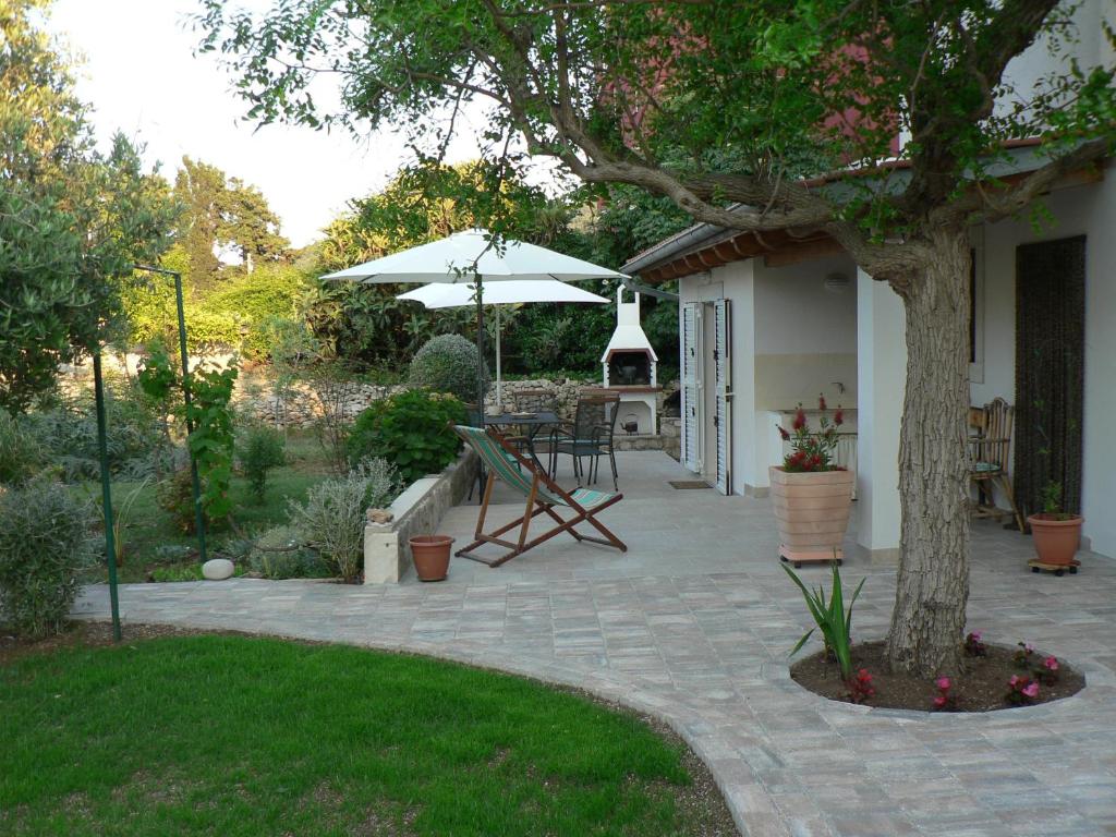 a patio with a table and an umbrella at Apartments Gabri in Mali Lošinj