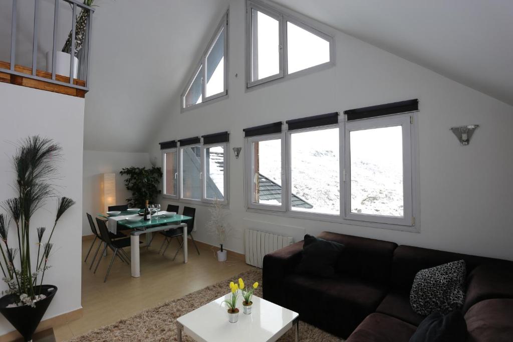 sala de estar con sofá y mesa en Miramar Ski a pie de pista - ÁTICO DUPLEX , 4 habitaciones en Sierra Nevada