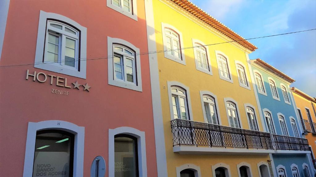 uma fila de edifícios coloridos numa rua em Hotel Zenite em Angra do Heroísmo