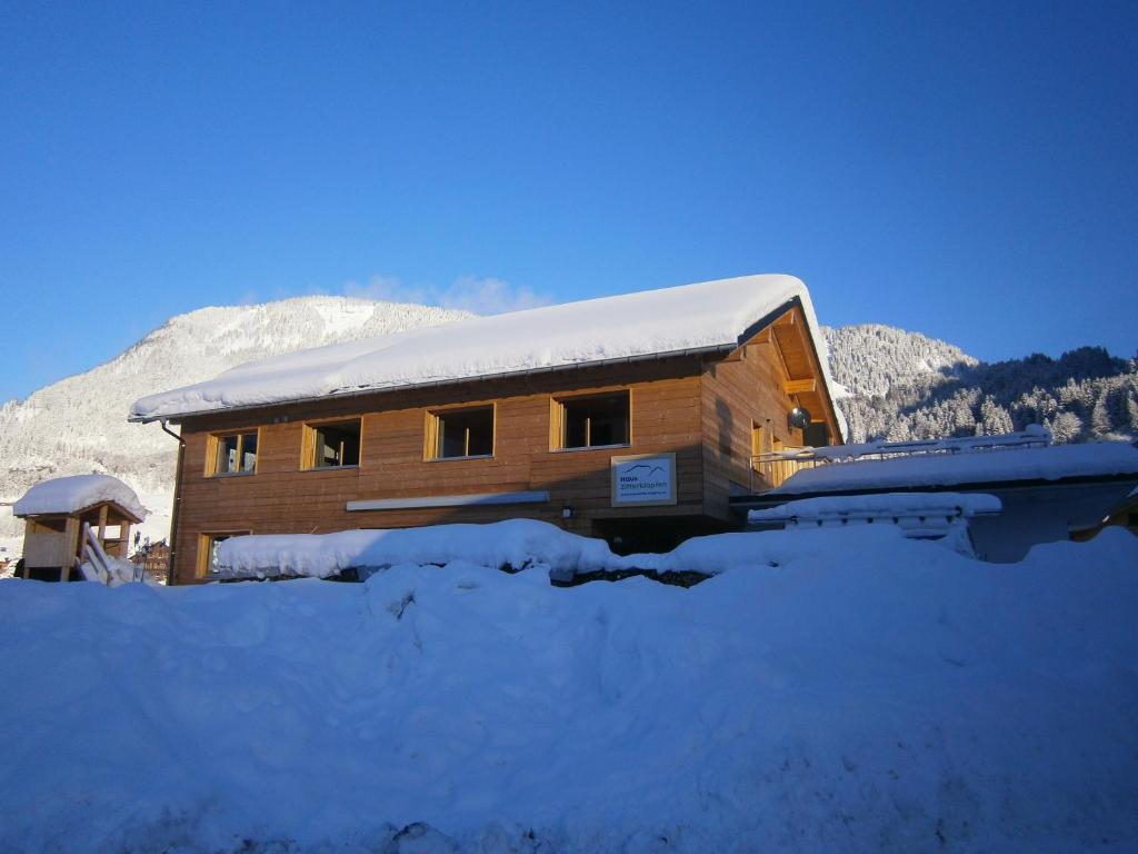 アウ・イム・ブレゲンツァーヴァルトにあるHaus Zitterklapfenの雪山の木造小屋