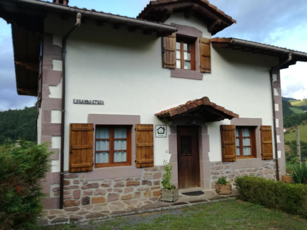 SumbillaにあるCasa Exkanda Etxeaの木製のドアと窓のある家