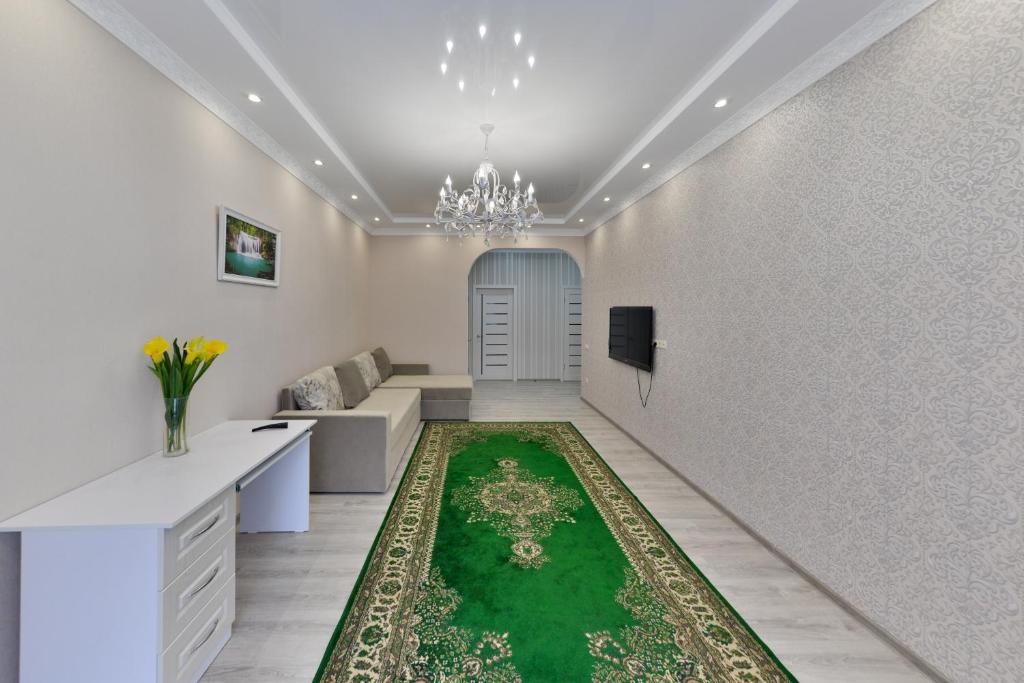 a living room with a green rug on the floor at Apartments LUX 53/144 in Astana