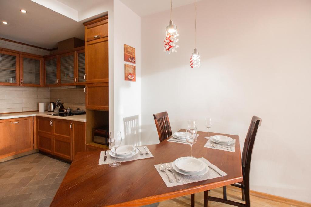 uma cozinha com uma mesa de madeira com cadeiras e uma sala de jantar em Riga City Center Apartment em Riga