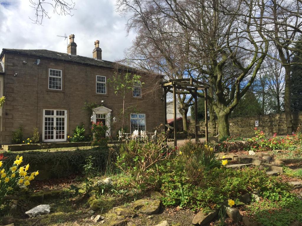 a brick house with a garden in front of it at Healey House Hotel in Batley