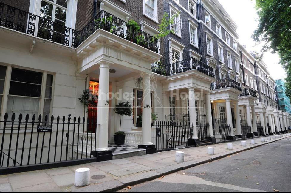 een gebouw met witte zuilen en balkons in een straat bij Rhodes Hotel in Londen