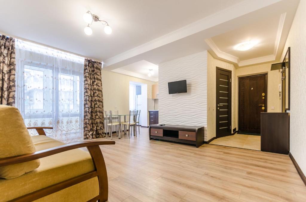 a living room with a couch and a tv on a wall at ARTAL Apartment on Obolonskyi Avenue 16a, 2 bedroom in Kyiv