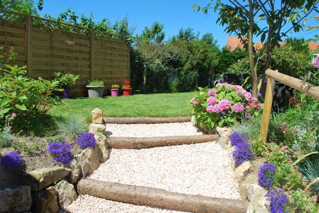 a garden with flowers and a stone path at La Saint Martinoise in Saint-Martin-Boulogne