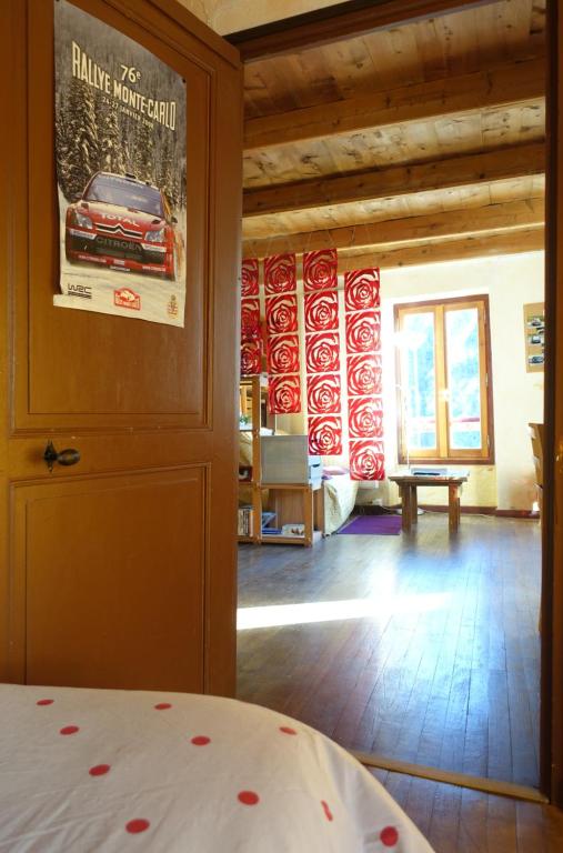a room with a bed with a poster on the wall at Au Bout De La Route in Prads-Haute-Bléone