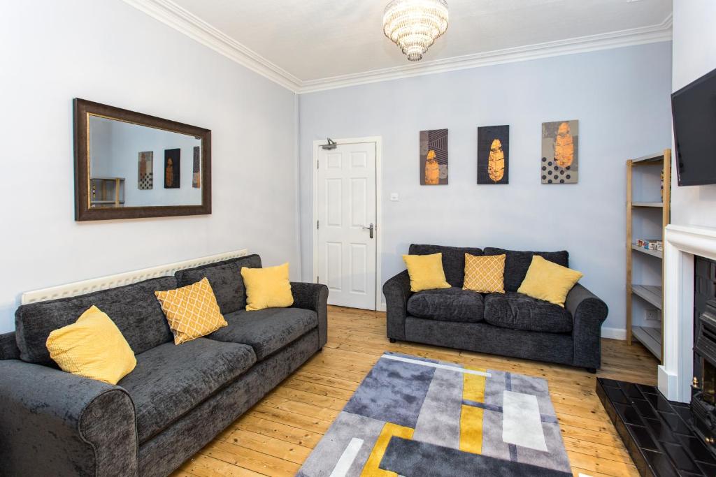 a living room with two couches and a mirror at Northwood Park View in Stoke on Trent