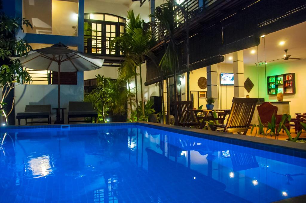 uma piscina num edifício com um restaurante em Private Boutique Home with Pool, The Fin Inn em Siem Reap