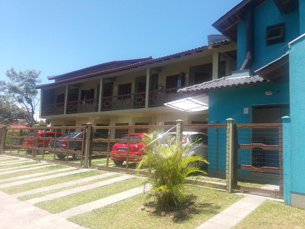 een blauw gebouw met auto's voor het gebouw bij Pousada Recanto da Barra Imbé in Imbé