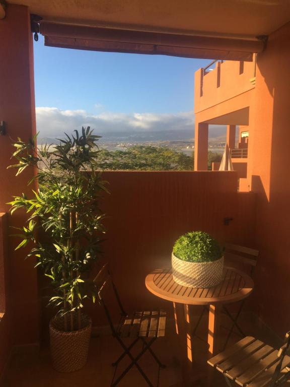 a balcony with a table and plants and a window at alquilaencanarias El Medano Sotavento, Great Terrace and beach in El Médano