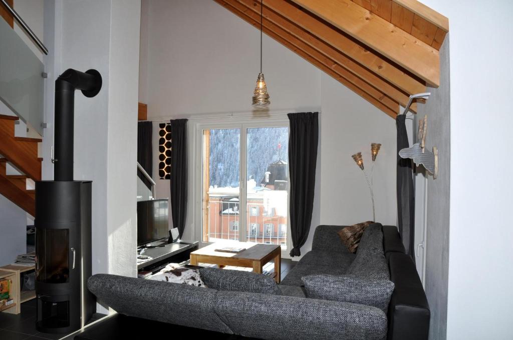 a living room with a couch and a tv at Chasa Döss 3 in Scuol