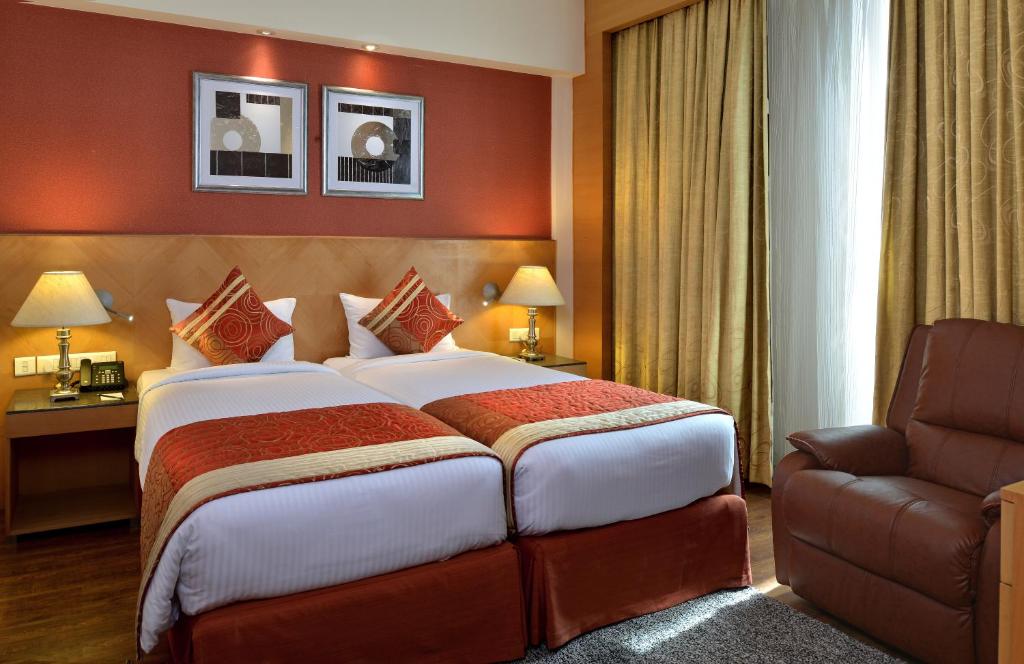 Postel nebo postele na pokoji v ubytování Savoy Suites Manesar