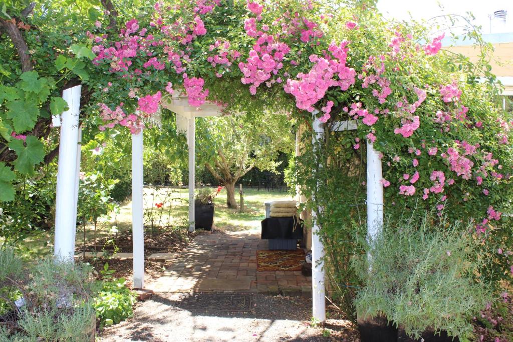 a pergola with pink flowers on it at Bellamona in Longford