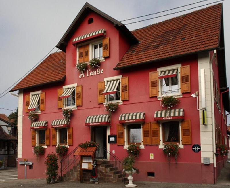 een rood gebouw met bloemen op de ramen bij Hotel Restaurant A l'Ange in Climbach