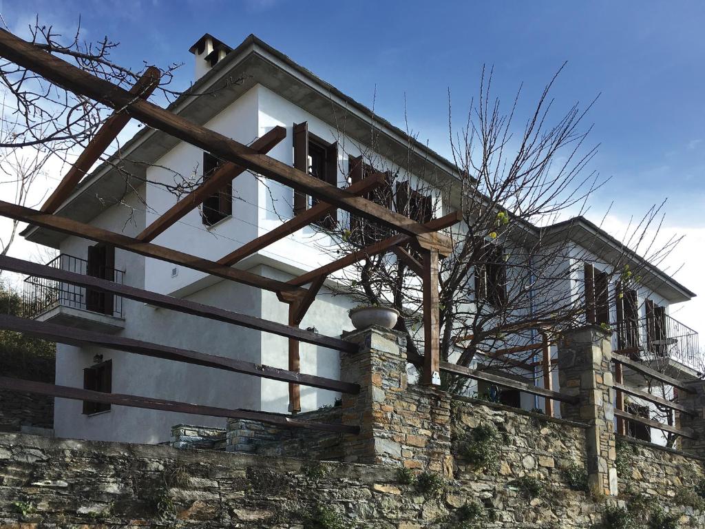 a building with wooden beams on top of a wall at Aethri Pelion Suites in Portariá