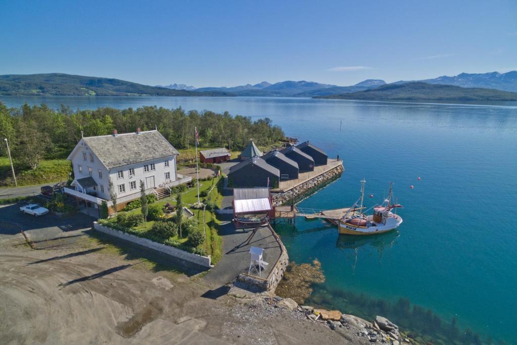 an aerial view of a house and a boat in the water at Finsnes Gaard in Finnsnes
