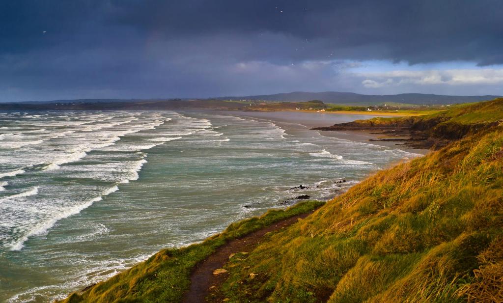 an aerial view of a beach with waves at Maison Lallier in Plonevez-Porzay