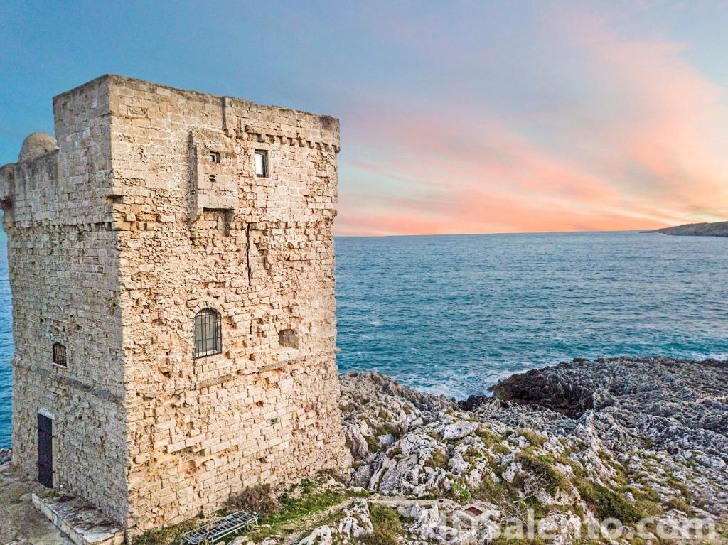 una vieja torre de piedra en la orilla del océano en Holidays Dream Veronica, en Alessano