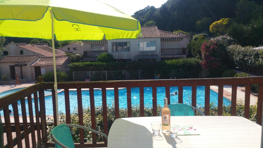 - une table avec un parasol jaune à côté de la piscine dans l'établissement Résidence Cap Azur Appartement 228, à Villeneuve-Loubet