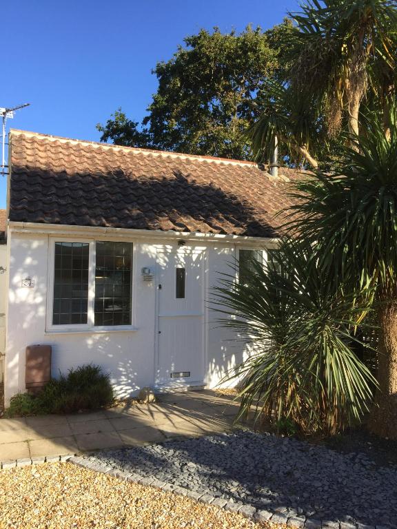 a white house with a palm tree in front of it at The Sail Loft - Hayling Island in South Hayling