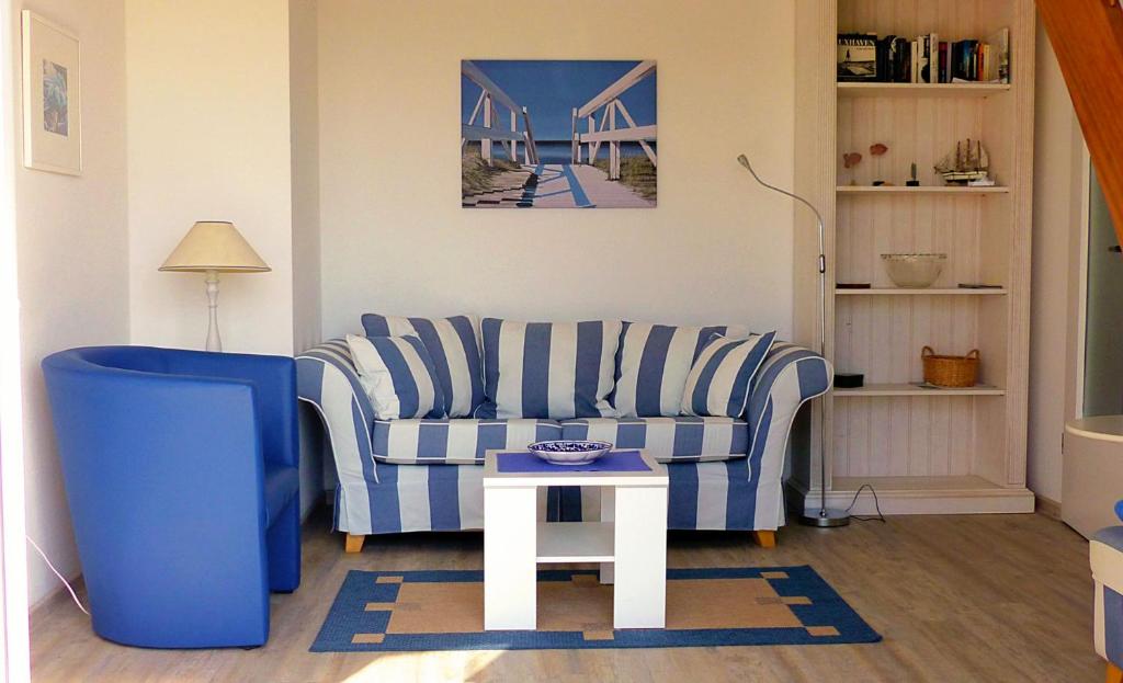 クックスハーフェンにあるFerienwohnung Meisennestのリビングルーム(青いソファ、テーブル付)