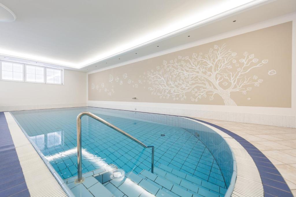 basen z muralem drzewa w obiekcie Park Hotel Bellevue w mieście Dobbiaco