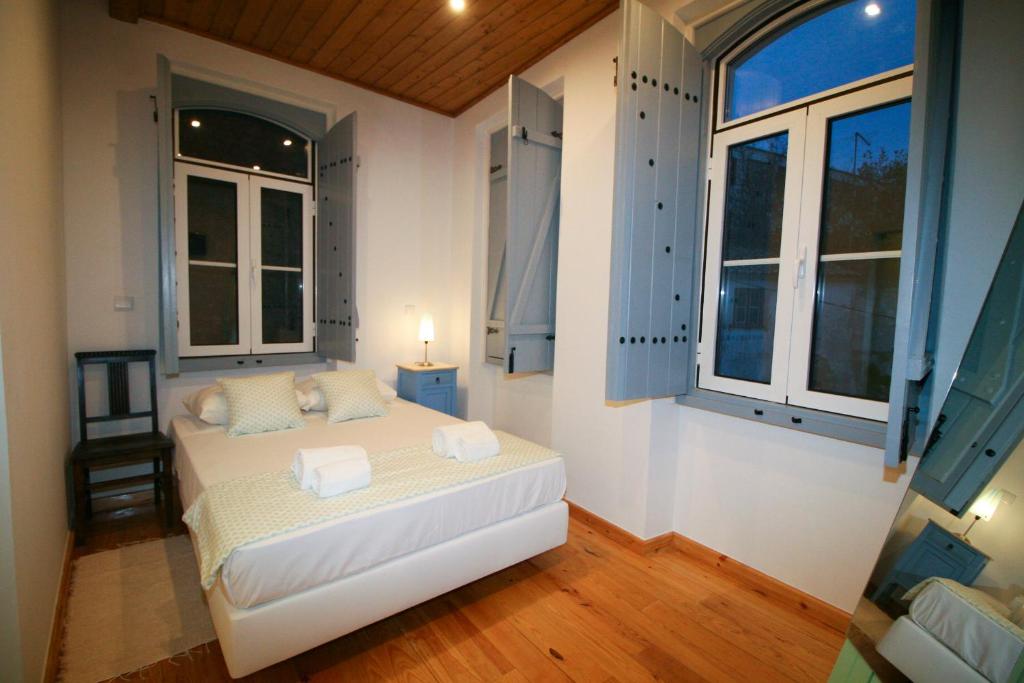 a bedroom with a bed and two windows at Casa dos Batalim in Monchique