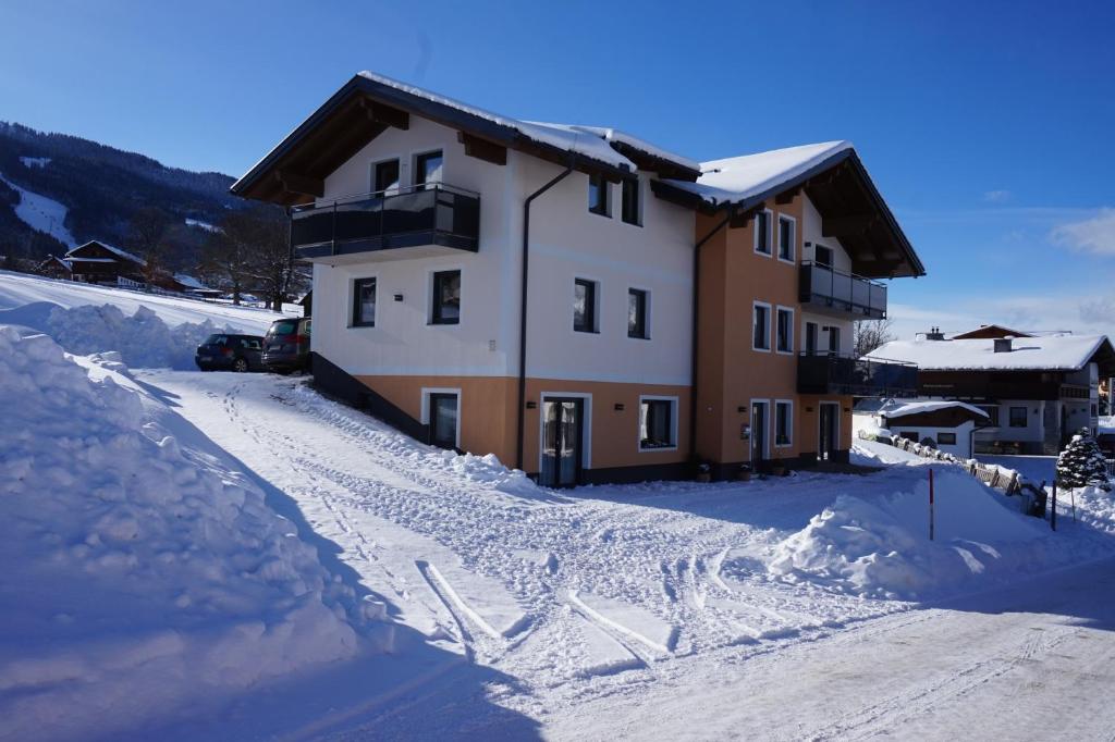 ein Haus im Schnee mit viel Schnee in der Unterkunft Appartements Real in Schladming