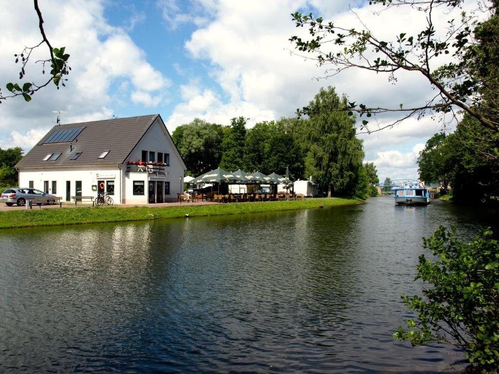 um edifício ao lado de um rio com uma casa em Lenzer Hafen em Lenz
