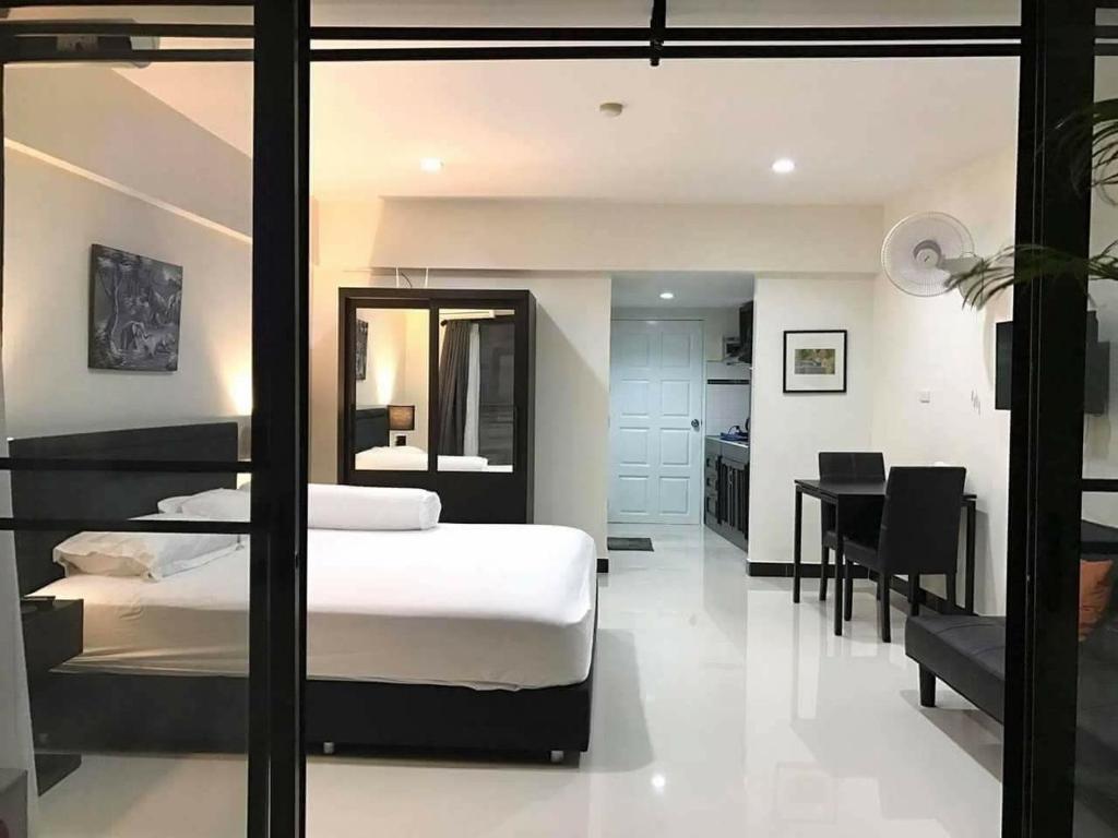 a bedroom with a bed and a desk in it at Vip condo chain by Linda in Ban Phe