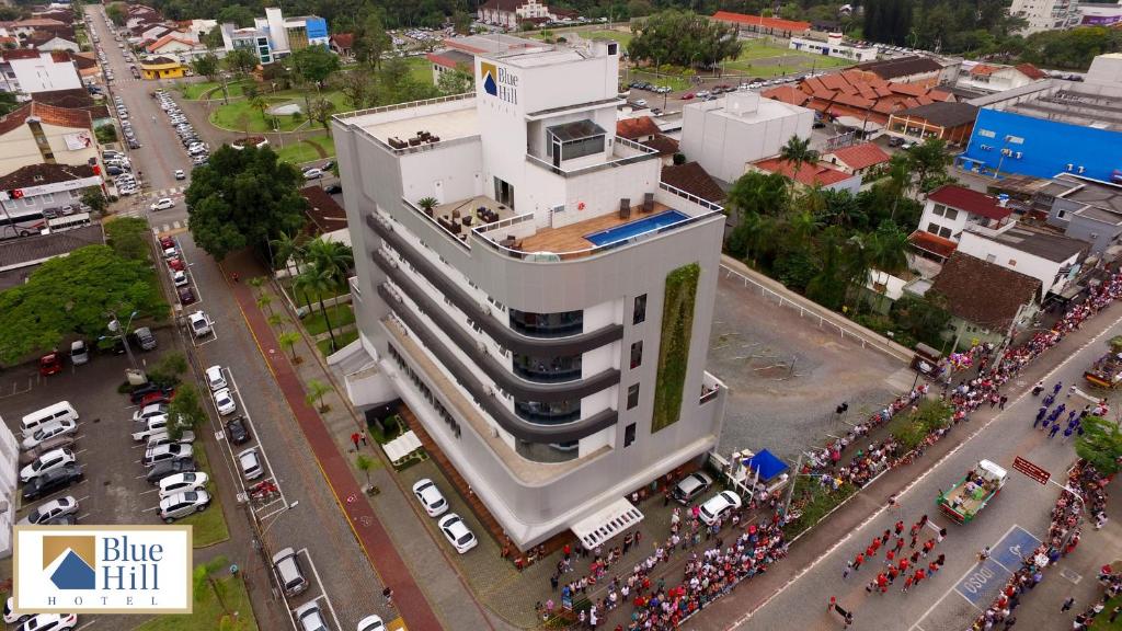 una vista aérea de una multitud de personas reunidas alrededor de un edificio alto en Blue Hill Hotel en Timbó