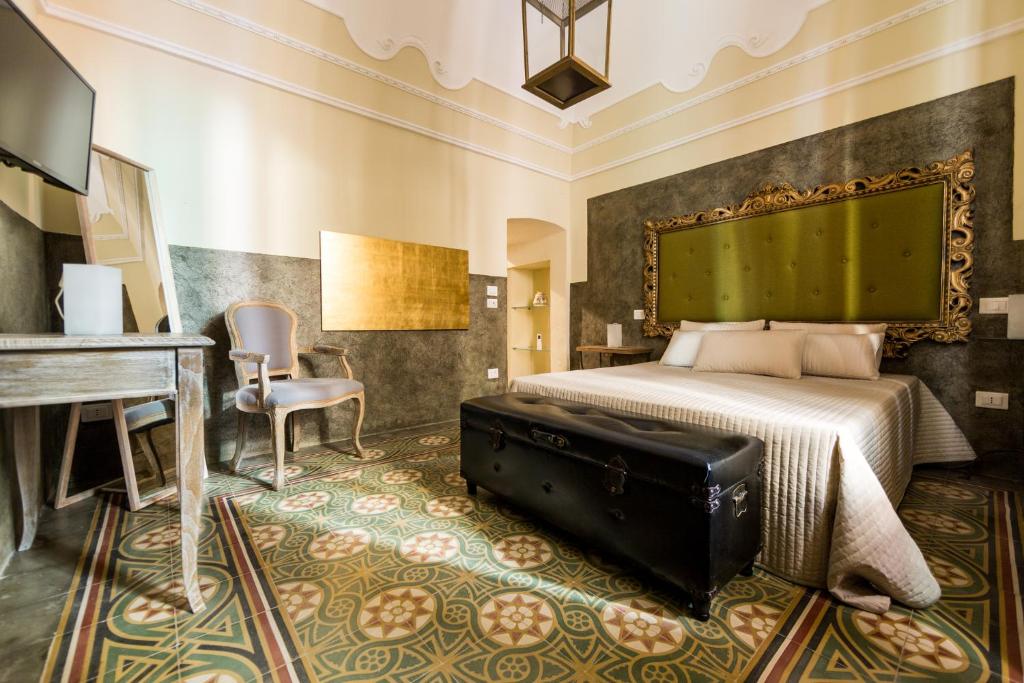 a bedroom with a bed and a desk and a piano at Suite Minerva in Polignano a Mare