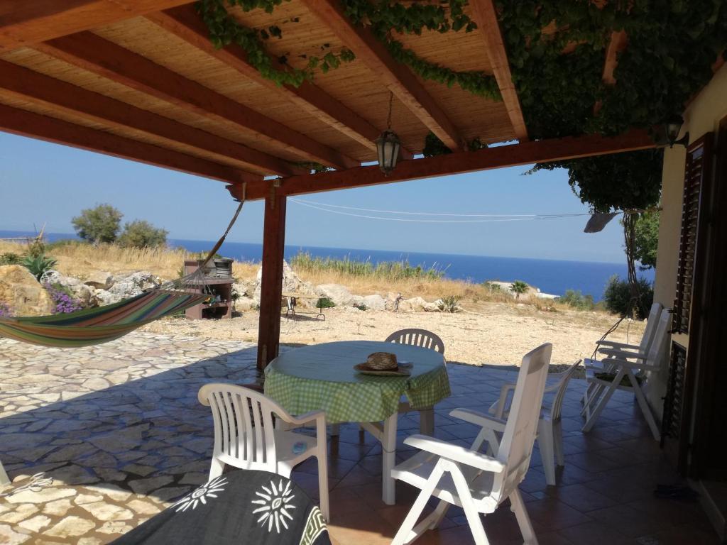 un tavolo e sedie su un patio con vista sull'oceano di Casetta Rosina a Scopello