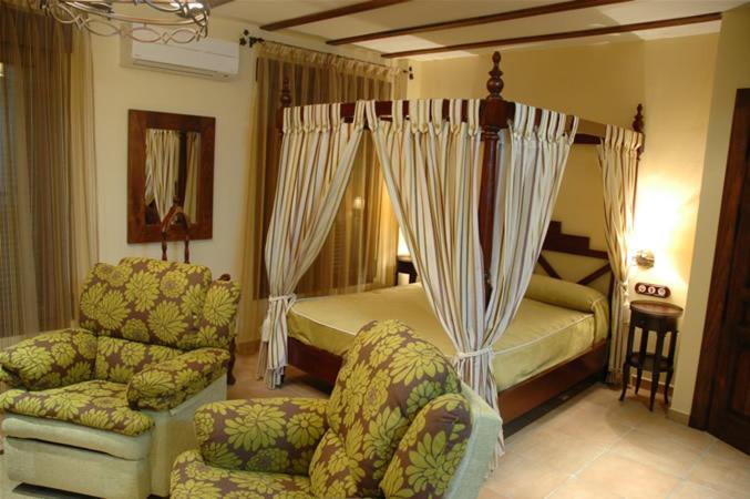 - une chambre avec un lit, une chaise et un canapé dans l'établissement La Azacaya, à Baeza