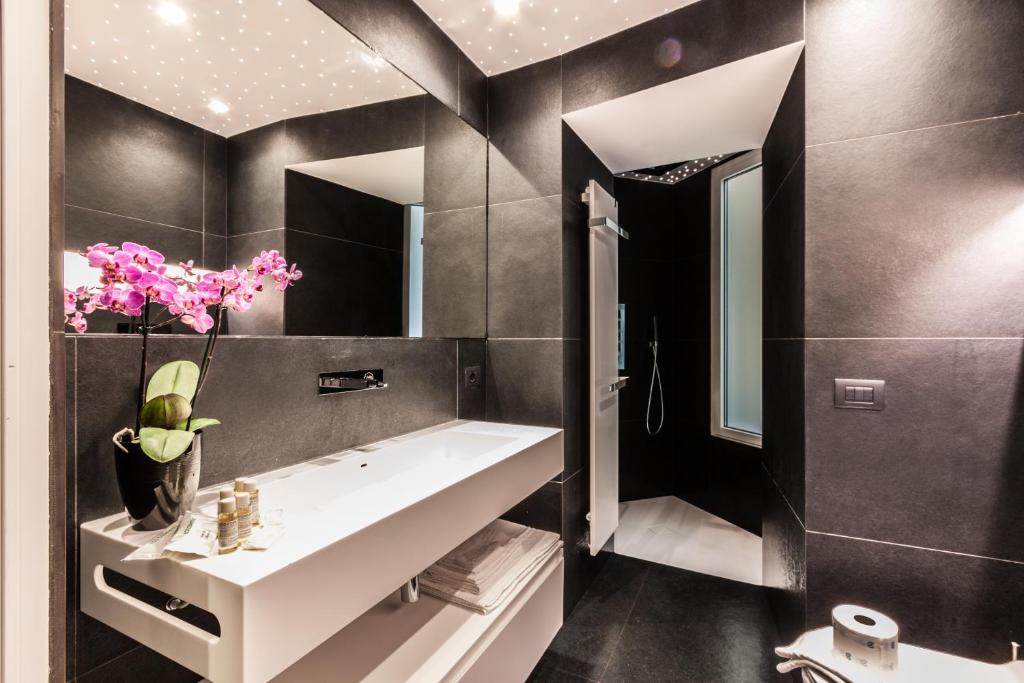 łazienka z białą umywalką i lustrem w obiekcie Domus Quiritum Elite, Vatican luxury apartment w Rzymie