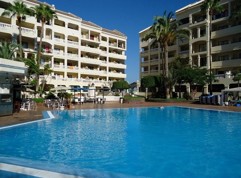 a large swimming pool in front of a building at castle harbour in Los Cristianos