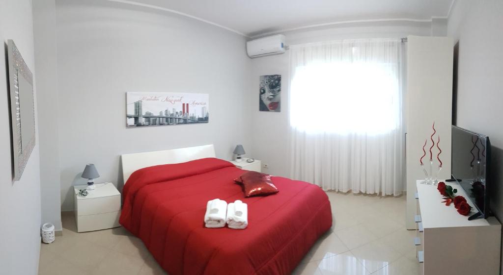 a bedroom with a red bed with two white towels at Catania Suite Home in Catania