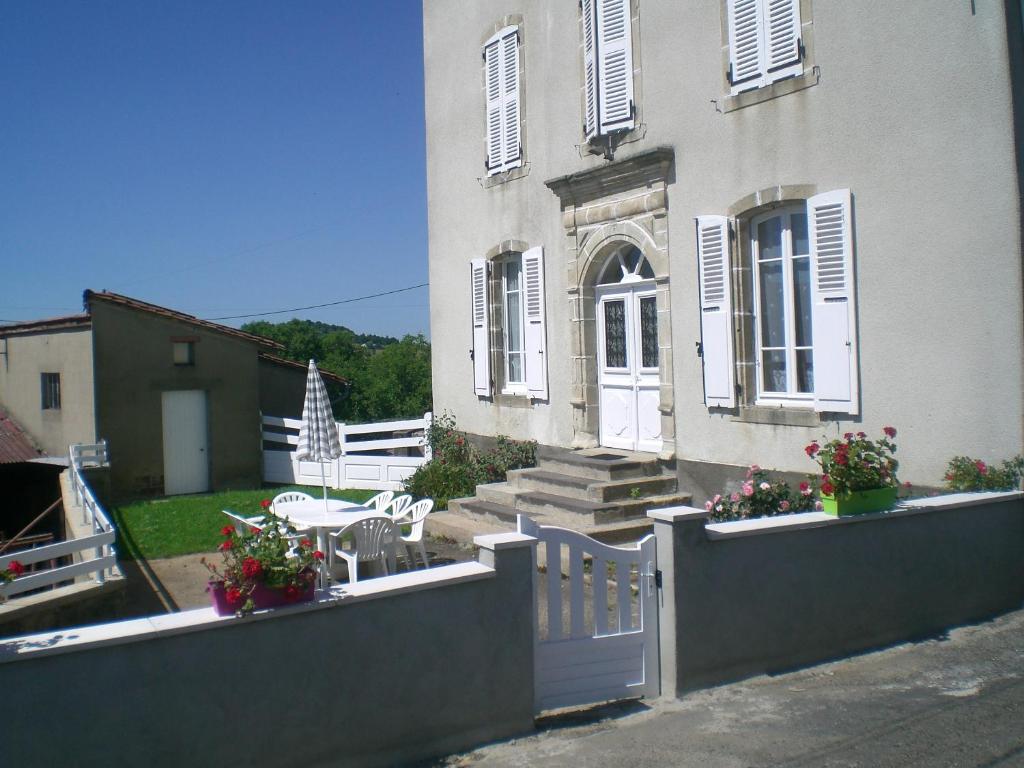 a white house with a fence and a table and chairs at chez mimoune in Trézioux