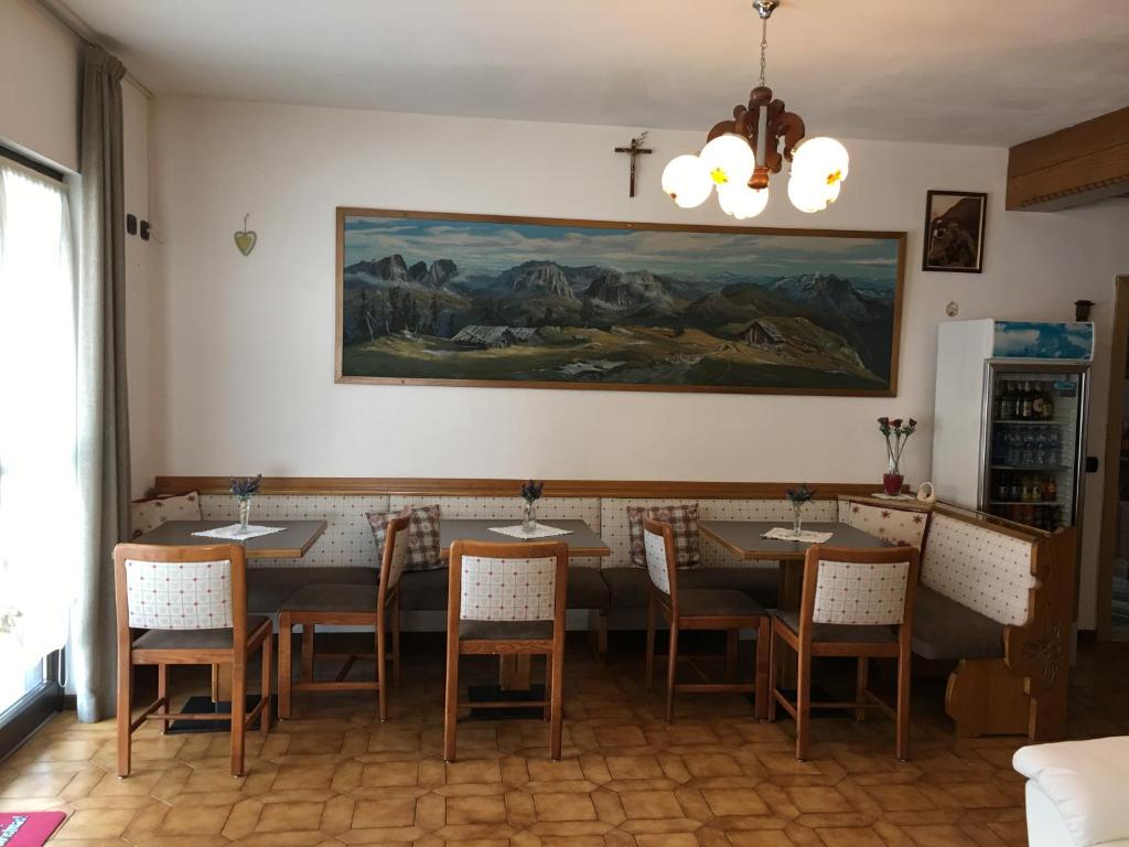 a room with a table, chairs, and a painting on the wall at Garni Festil in Campitello di Fassa