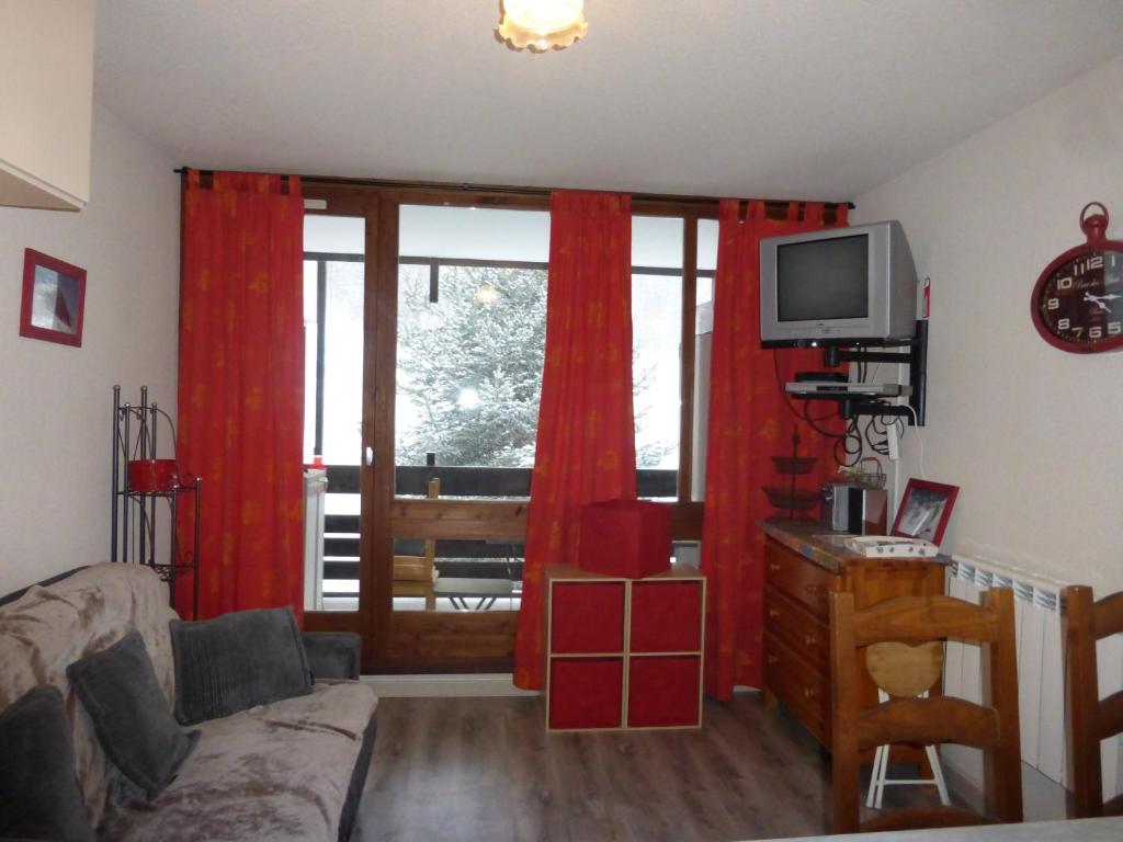 ル・ソーズにあるZENITH 2015のリビングルーム(赤いカーテン、テレビ付)